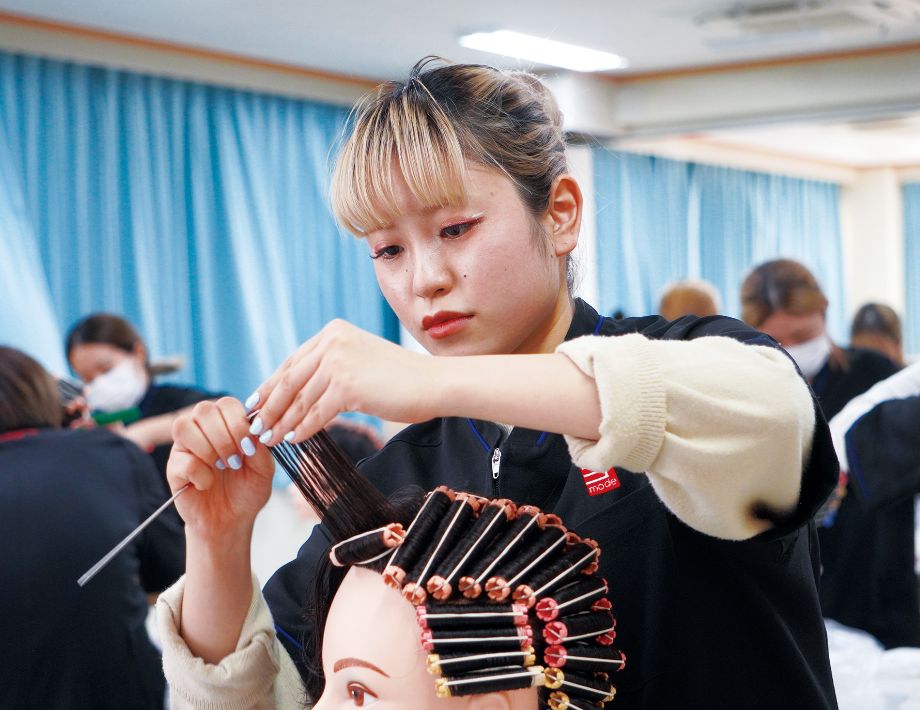 美容学生がワインディングの練習をしている様子