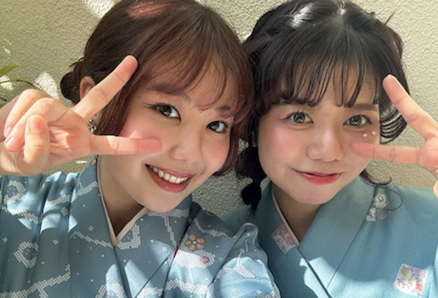 二人の学生がピースをしている写真