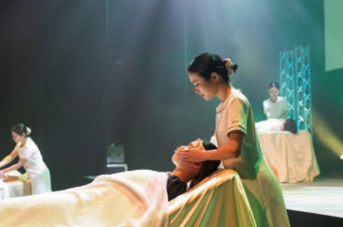 トータルビューティー科の学生がステージ上でエステの技術を披露している様子