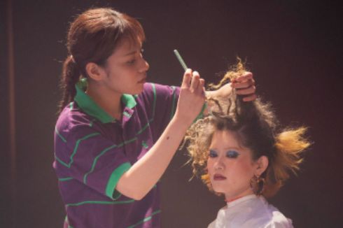 美容科の学生がヘアメイクライブでモデルのヘアメイクをしている様子