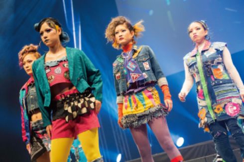 ドレスアップした美容科の学生がステージ上でポーズをとっている様子