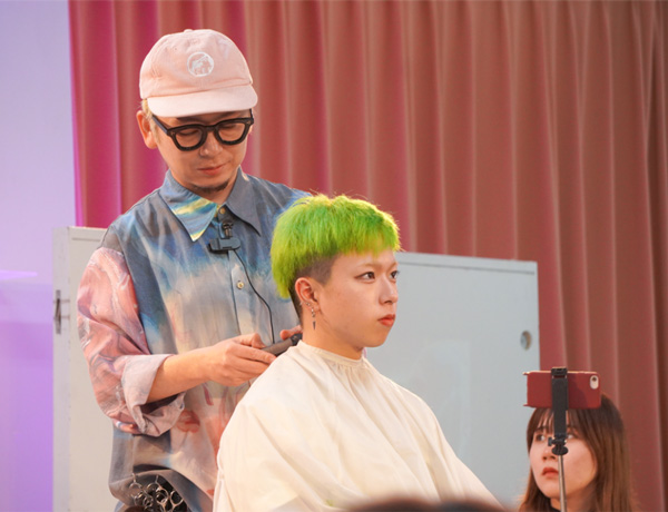 講師がモデルにヘアアレンジをしている様子