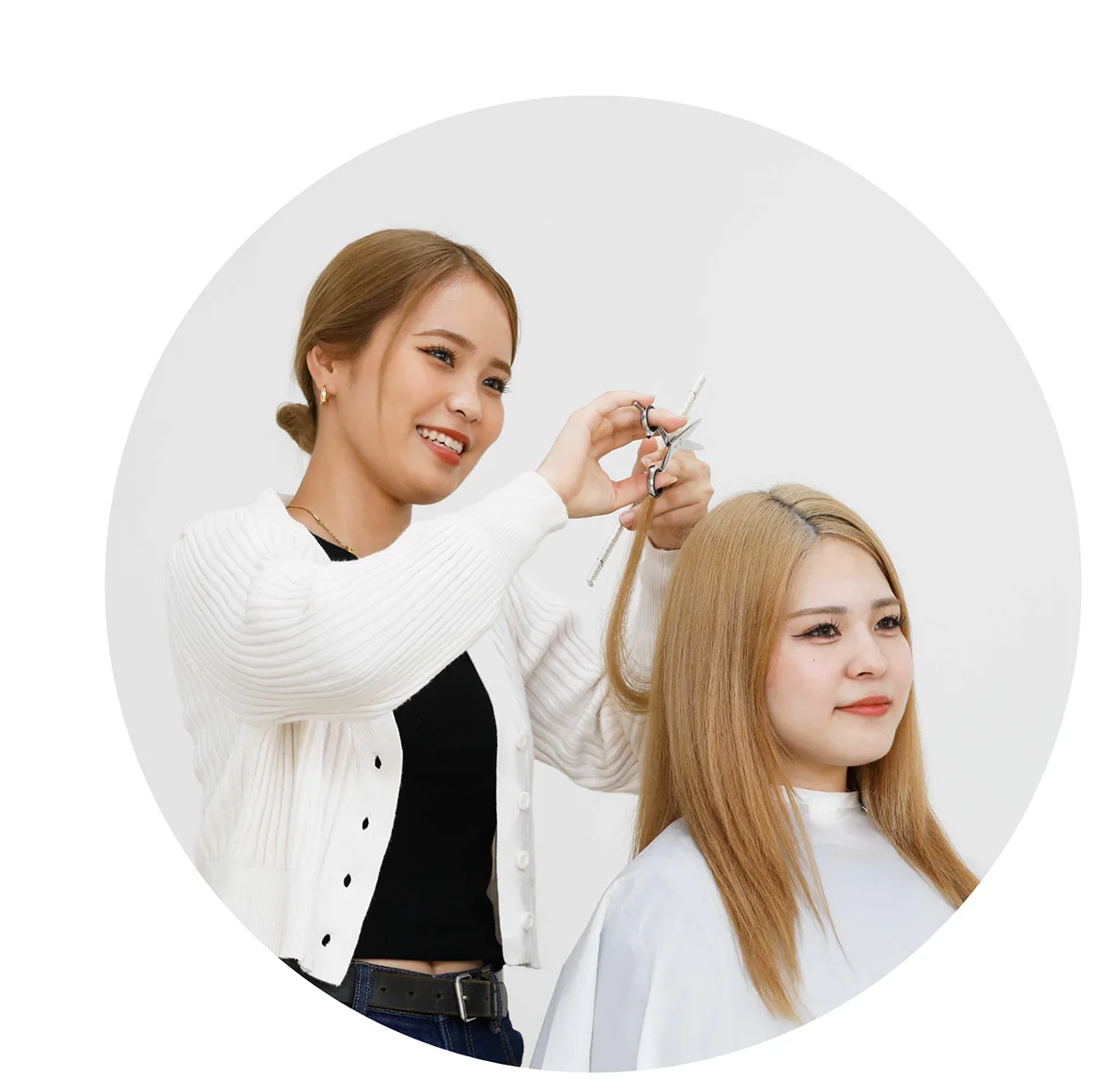 女性の美容学生がカットの練習をしている様子