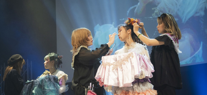 ステージ上でモデルをメイクしている様子