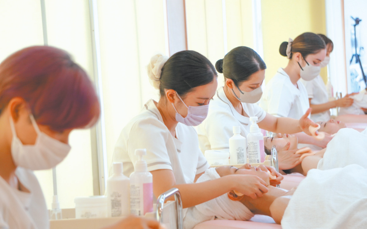エステの施術練習をしている美容学生たち