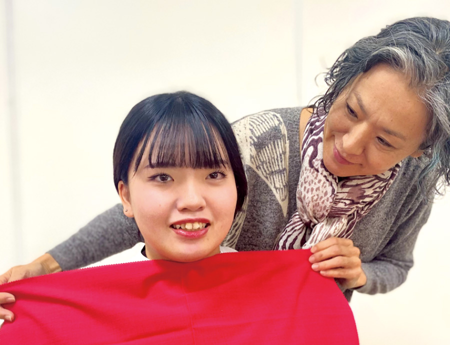 講師がモデルにクロスをかけている様子