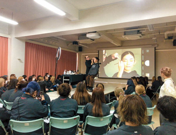 講師が大勢の学生の前で実習をしている様子